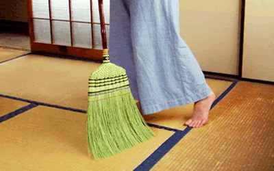 部屋を掃く女性